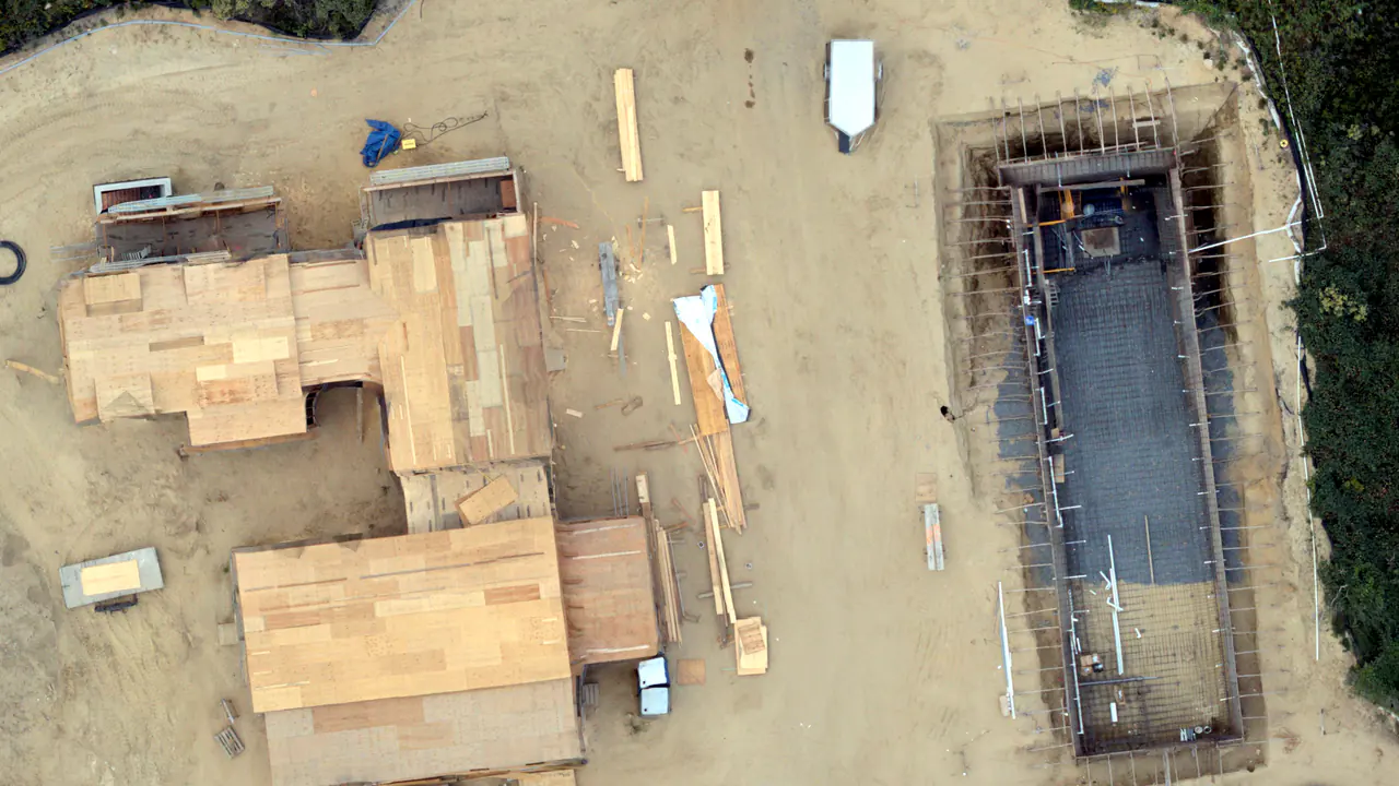 Construction progress orthophoto showing the building site, access, and staging areas